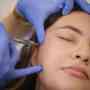 Image of a woman receiving a Botox injection in her cheek.