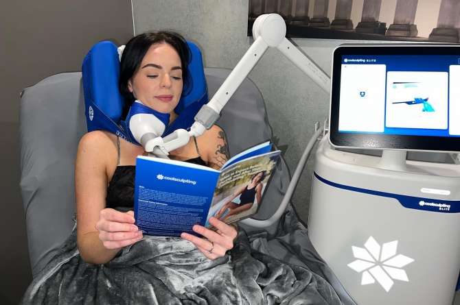 Image of a patient reading a pamphlet while receiving coolsculpting treatment.
