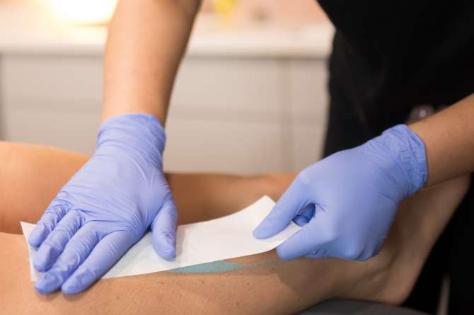Leg blue wax application woman
